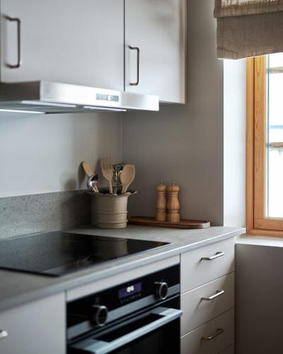 a kitchen with white cabinets and a stove top oven at Lofsdalens Fjällhotell & Hotellbyns Lägenheter in Lofsdalen