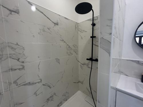 a bathroom with a shower with marble tiles at Gabrielle hôtel in Aiguines