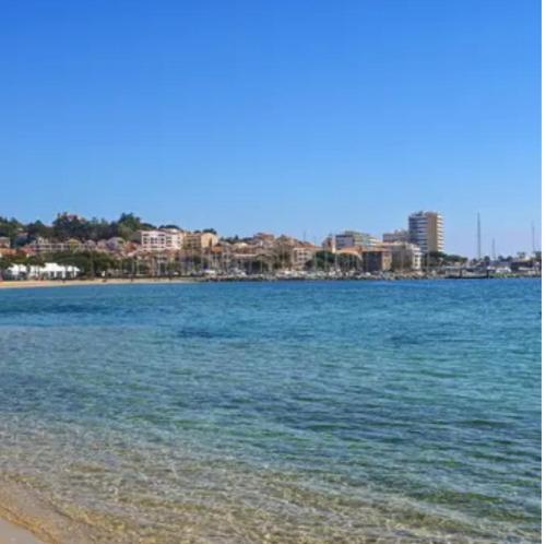 a view of a beach with a city in the background at Studio proche plage et centre-ville in Sainte-Maxime