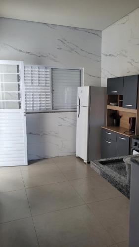 a kitchen with a white refrigerator in a room at Apartamento térreo no Centro in Sorriso