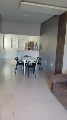 a living room with a table and chairs and a couch at Apartamento térreo no Centro in Sorriso