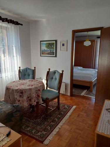 a room with a table and two chairs and a bedroom at Star in Mali Lošinj