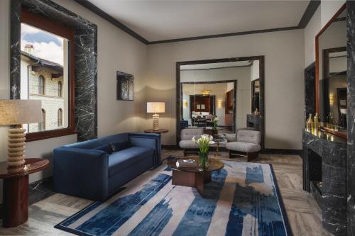 a living room with a blue couch and a table at Palazzo Ottaviani - Luxury Apartments in Florence