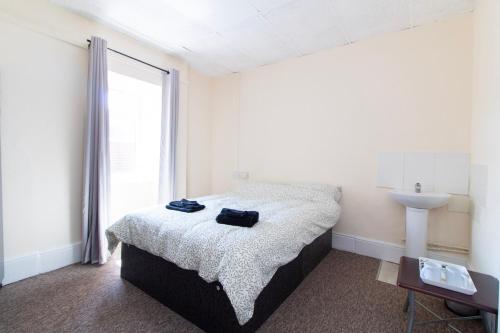 a bedroom with a bed and a sink and a window at Brookvale Guest House Room 3 in Southampton