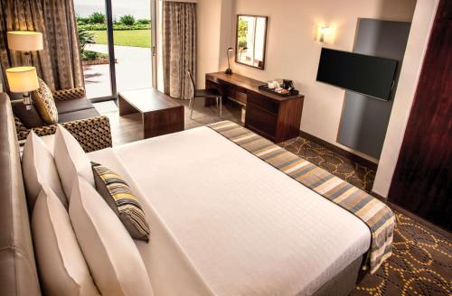 a hotel room with a bed and a television at Garden Court South Beach in Durban