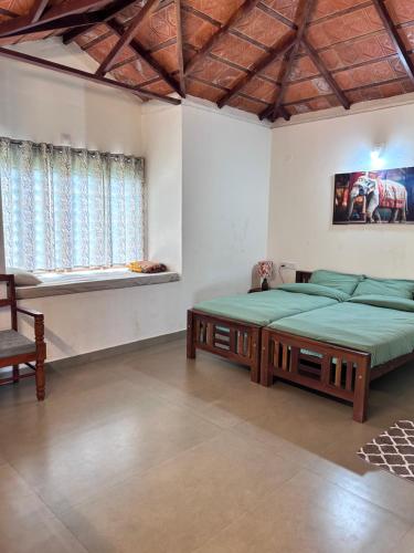 a bedroom with two large beds and a window at Heritage Farm Kerala in Idukki