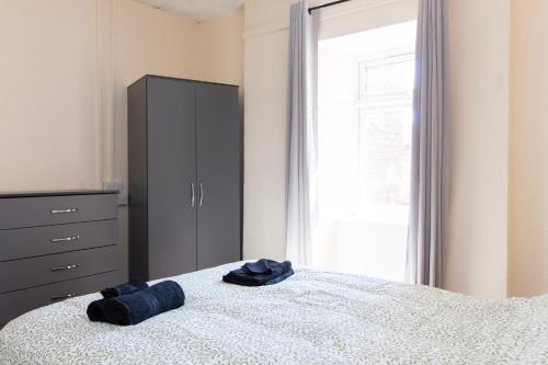 a bedroom with a bed with a dresser and a blue hat at Brookvale Guest House Room 3 in Southampton
