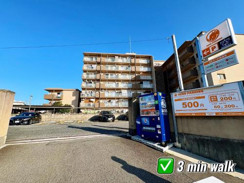 a parking lot with a apartment building in the background at Yuki's house - Kyoto single-family house, 3 minutes to the nearest bus stop in Kyoto