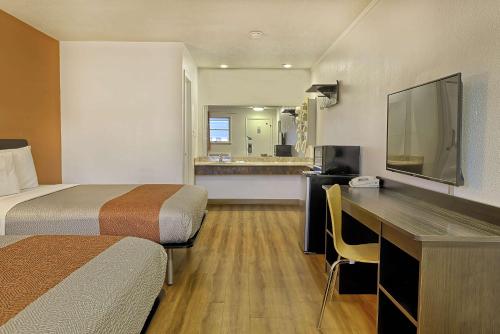 a hotel room with two beds and a desk with a television at Motel 6 Sullivan MO in Sullivan