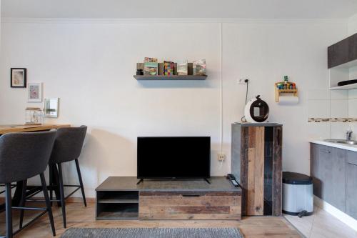 a living room with a flat screen tv on a wooden table at Haus Tannenberg in Todtnau
