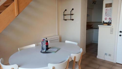 奥斯坦德Modern renovated duplex with unique and calming view T33的小厨房配有白色的桌椅