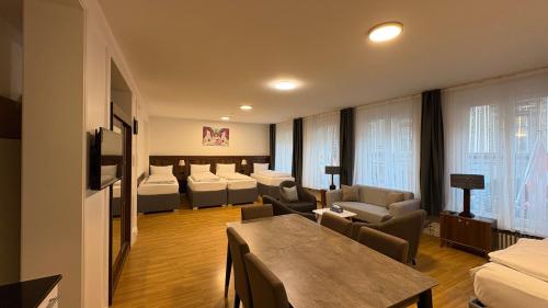a hotel room with beds and chairs and a table at Akomo Bern in Bern