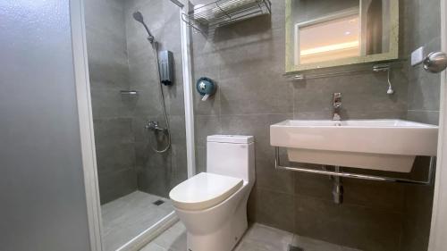 a bathroom with a toilet and a sink and a shower at 台東漫活電梯民宿-可包棟 in Taitung City