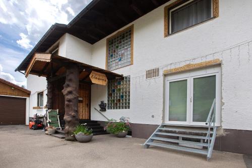 a white house with a porch and a window at Haus Tannenberg in Todtnau