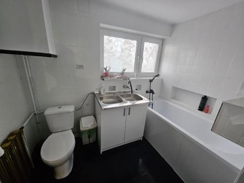 a white bathroom with a toilet and a sink at Apartament Ogrodowa in Biała Podlaska