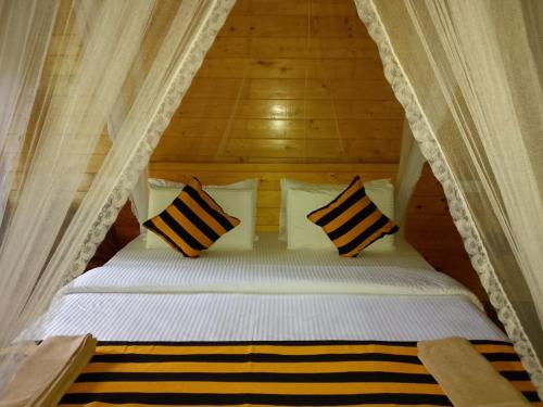 a bed with four pillows in a tent at Natural mountain in Nikawatawana
