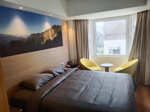 a bedroom with a large bed with a painting on the wall at Astoria Veg-A Vegetarian Hotel in Kodaikānāl