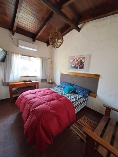 a bedroom with a large red bed and a desk at PORTAL DE LA OVEJERIA in Tafí del Valle