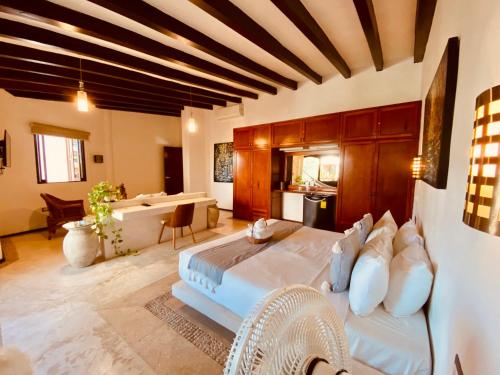 a large bedroom with a large bed and a kitchen at Hotel Para Ti - Adults Only in Holbox Island