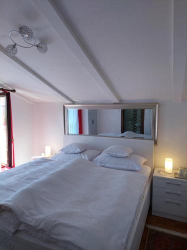 a bedroom with a large white bed with two pillows at Star in Mali Lošinj