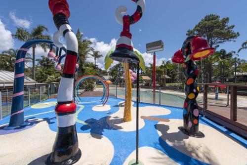 a water park with a playground with colorful play equipment at Wairo Beach Holiday Park in Lake Tabourie