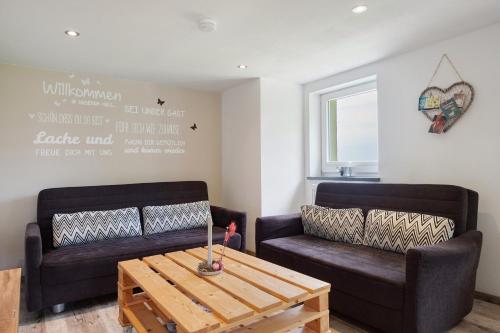 a living room with two couches and a coffee table at Bäuerleshütte in Breitnau