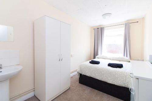 a white bedroom with a bed and a sink at Brookvale Guest House Room 5 in Southampton