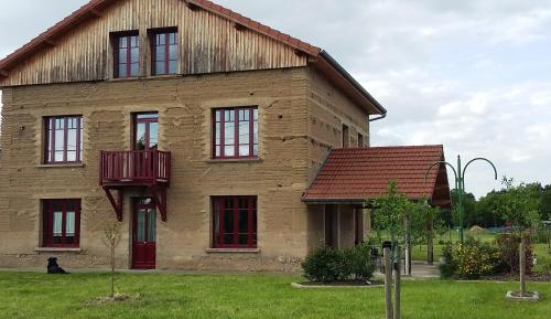 a building with a balcony on the side of it at Maison d'hôtes La Tuilerie in Peschadoires