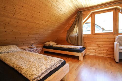 a bedroom with two beds in a log cabin at AlpenChalets Ausseerland in Bad Mitterndorf