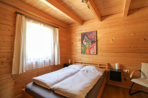 a bedroom with a bed in a wooden cabin at AlpenChalets Ausseerland in Bad Mitterndorf