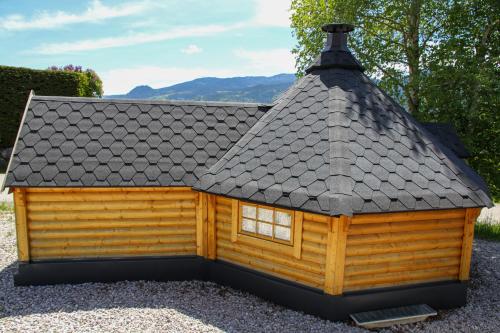 a small log cabin with a black roof at AlpenChalets Ausseerland in Bad Mitterndorf