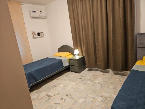 Una pequeña habitación con dos camas y una mesita de noche en شقة 3غرف نوم في ضاحية الرشيد, en Amán