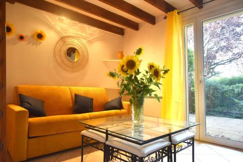 - un salon avec un canapé jaune et une table en verre dans l'établissement Repos et Tranquillité - Super Calme de la campagne - Clim - Grande Piscine Partagée au Sel - Déco cosy tout confort - Proche Commodités, à Montélimar