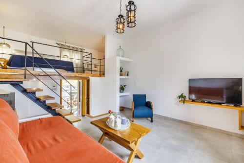 a living room with an orange couch and a staircase at Irida Apartments in Stafylos