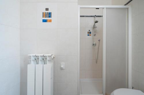 a white bathroom with a shower and a toilet at Case Vacanze Otranto in Otranto