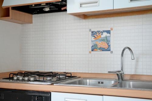 a kitchen with a sink and a stove at Case Vacanze Otranto in Otranto