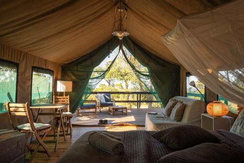 a living room with a tent with a table and chairs at Eco Glamping Portugal Nature Lodge in São Luis