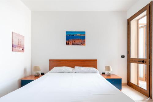 a bedroom with a white bed with two tables and a window at Case Vacanze Otranto in Otranto
