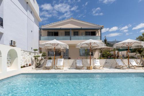 a house with a swimming pool with chairs and umbrellas at Dimitri Hotel in Himare