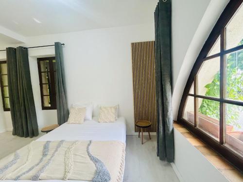 a bedroom with a bed and a large window at Gabrielle hôtel in Aiguines