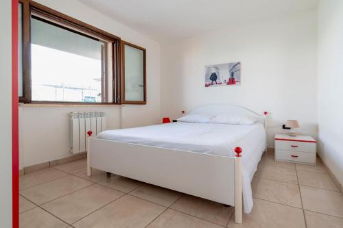 a white bedroom with a bed and a window at Case Vacanze Otranto in Otranto