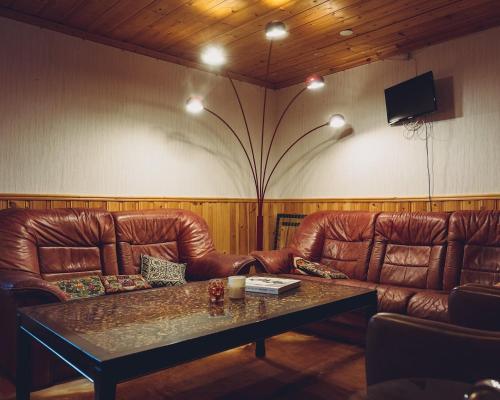 a living room with two leather couches and a table at Lofsdalens Fjällhotell & Hotellbyns Lägenheter in Lofsdalen