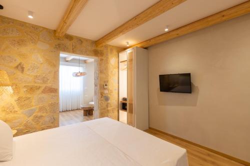 a bedroom with a bed and a tv on a wall at Dimitri Hotel in Himare