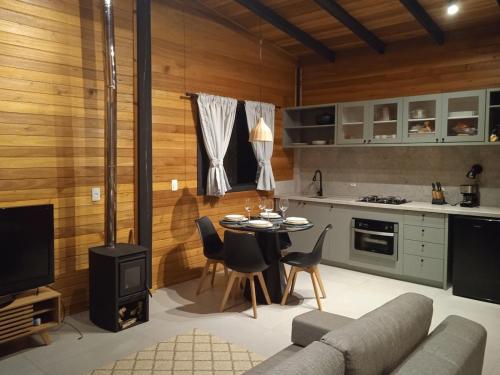 a living room with a couch and a table with chairs at Beautiful Cabin in the Serra Catarinense in Bocaina do Sul