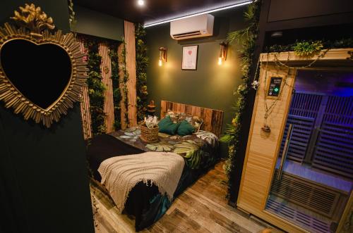 Cette chambre comprend un lit et un miroir. dans l'établissement Suite Jungle Spa - Sauna & Balnéo, à Château-Thierry