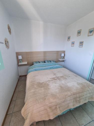 une chambre avec un grand lit dans une pièce blanche dans l'établissement Appartement cosy avec piscine chauffée, à Cabourg