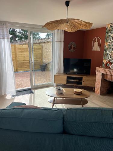 a living room with a couch and a table at Chez Colette- Maison avec jardin in Acquigny