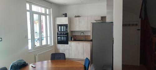 une cuisine avec une table et un réfrigérateur dans l'établissement Maison avec vue mer, à Berck-sur-Mer