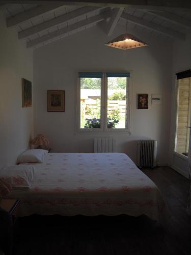 une chambre avec un lit et deux fenêtres dans l'établissement Charmant studio indépendant au calme 5mn des plages, à Soorts-Hossegor