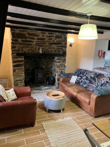 a living room with a couch and a stone fireplace at Knockers Retreat, St Agnes in St. Agnes